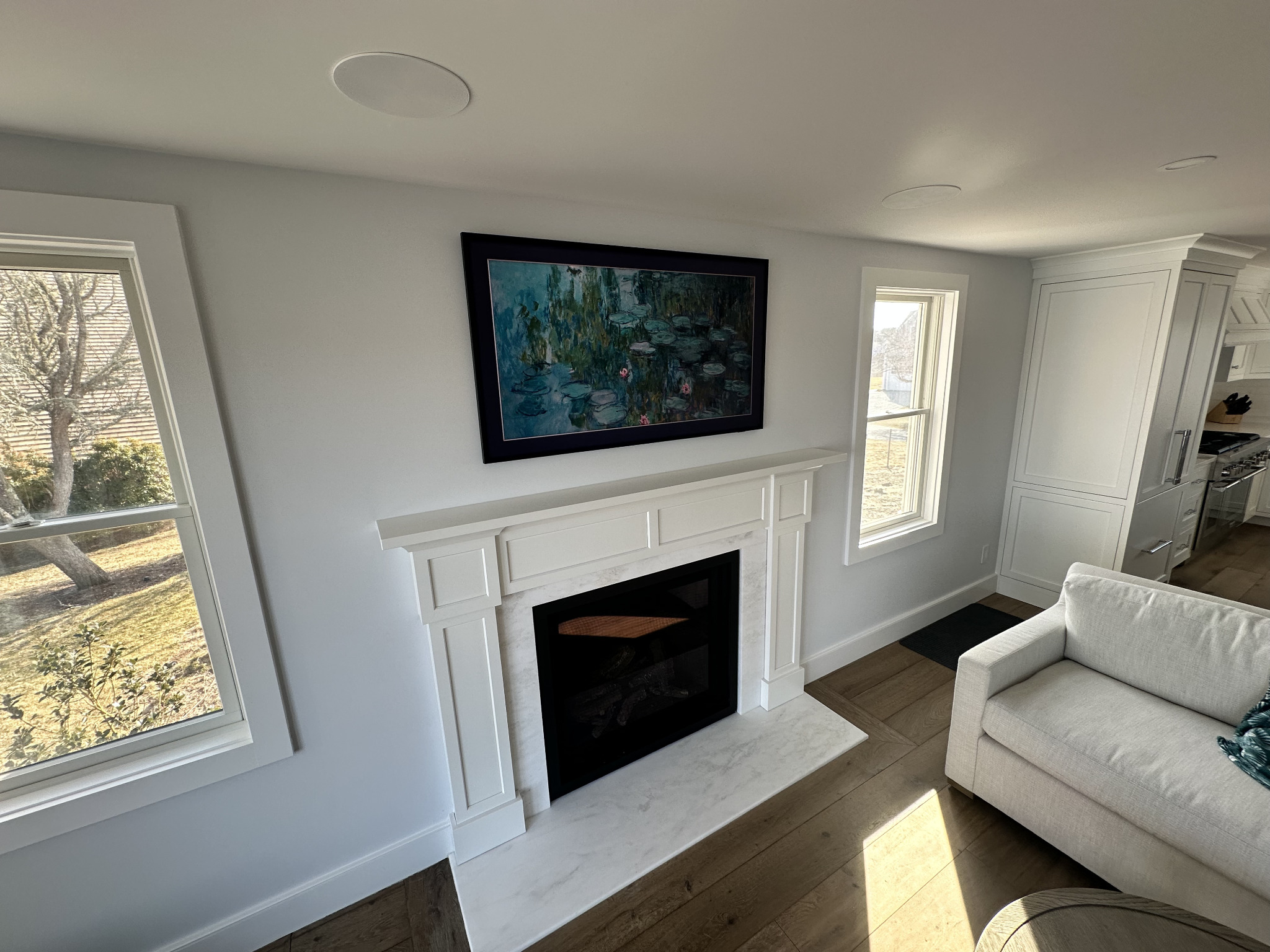 Finished TV installation above a fireplace in a clean living room